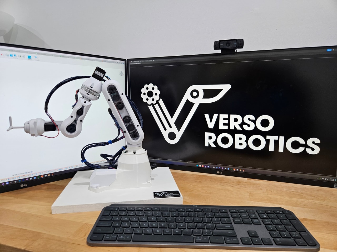 A wide view of the desk with Verso, a keyboard, and two monitors.